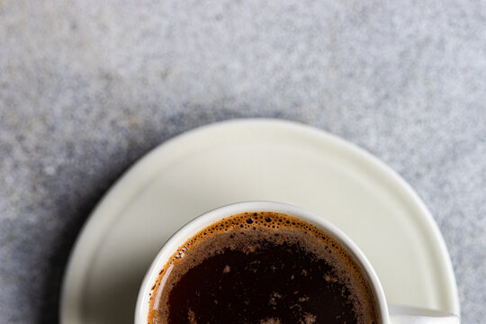 Freshly brewed coffee in a white cup on a saucer