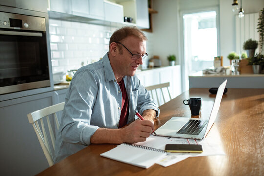 Stressed man going over bills at home