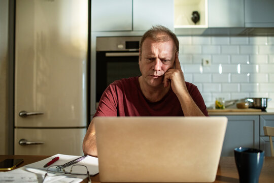 Stressed man going over bills at home