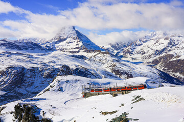 Cogwheel train of the Gornergrat Railway climbing the mountain facing the Matterhorn above Zermatt...