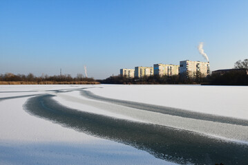 Winter landscape of a frozen lake. View of Soviet buildings. Wide panorama. 