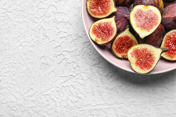 Bowl with fresh ripe figs on white background