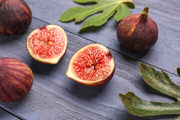 Fresh ripe figs and leaves on blue wooden background