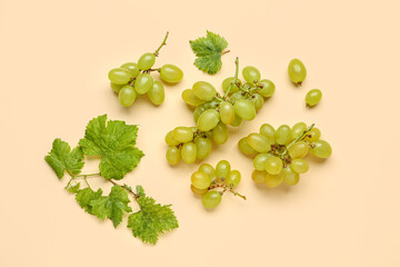 Fresh green grapes with leaves on orange background