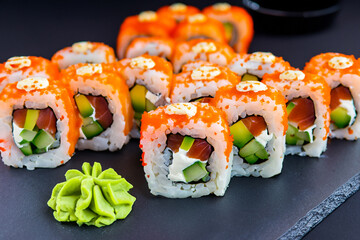 Delicious sushi on a dark background. Tasty sushi on a graphite plate. Sushi Filadelfia. Generative AI image. 	
