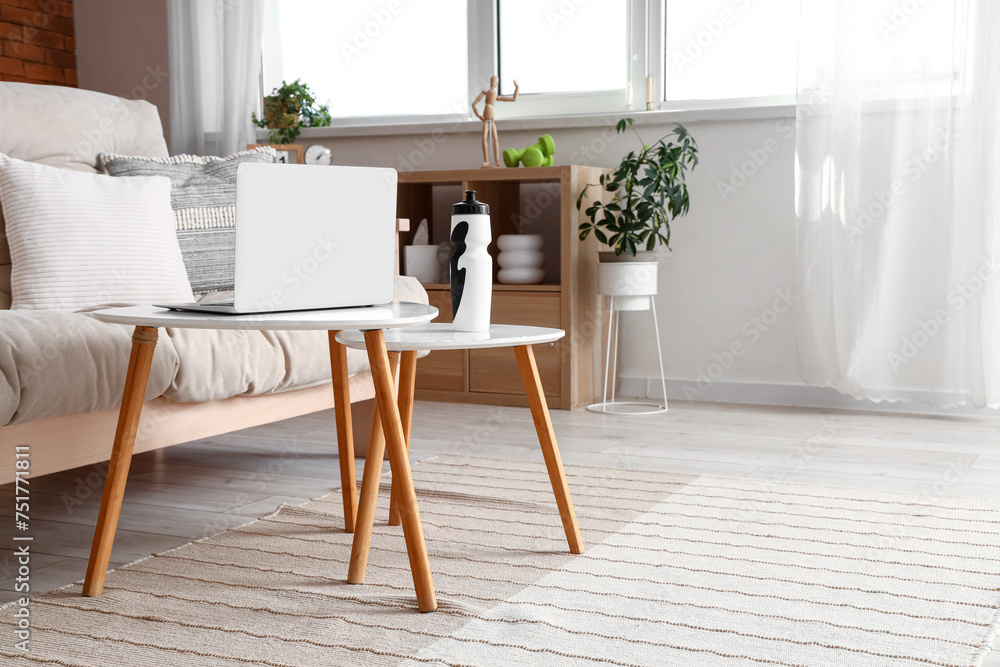 Poster Laptop with sports water bottle on table in living room