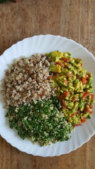 Prato vegano preparado com guacamole de abacate com tomate, virado de couve com farinha de mandioca e arroz integral com lentilha.