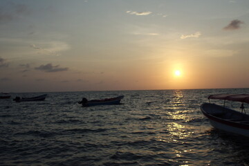 Naklejka premium sunset on the beach with boat
