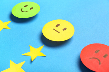 Rating smiles with stars on blue background, closeup. Customer experience concept