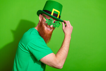 Profile portrait of cool person hand touch hat shamrock shape glasses empty space isolated on green...