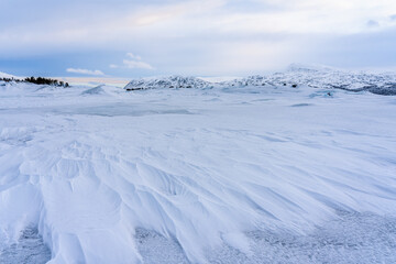 Fototapeta na wymiar Snow on frozen Akkajaura in Swedish Lapland
