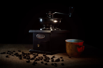 Coffee beans with retro manual coffee grinder and coffee cup with red heart