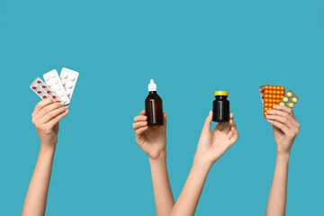 Female hands holding pills in blister packs and medicines on blue background