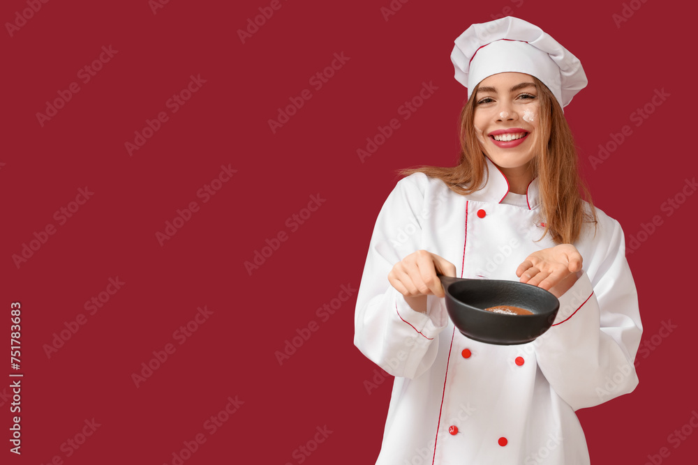 Sticker Happy young female chef showing frying pan with tasty pancake on red background