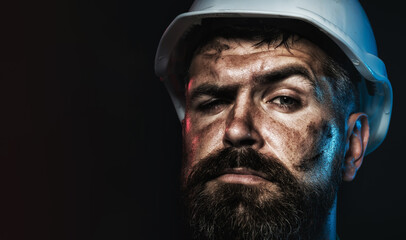 Closeup portrait of construction worker in hard hat. Pensive bearded man in protective helmet. Serious professional architect, contractor or male builder in safety hardhat. Copy space for advertising.