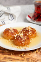 Kemalpasa dessert with milk. Turkish and Middle Eastern cuisine desserts. Ramadan meal. Kemalpaşa dessert on a wooden serving board
