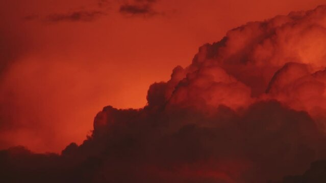 Dramatic fiery red clouds at sunset. Atmospheric phenomena and weather patterns concept. Design for meteorological education, climate change awareness campaigns, and nature photography exhibitions.