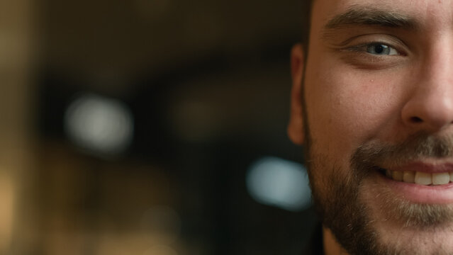 Half face portrait male human head close up view masculine facial part Caucasian handsome man with beard smiling toothy dental smile client of ophthalmology clinic healthy eyes sight. Empty copy space