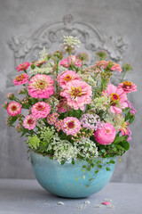 Kompozycja letnich różowych kwiatów w ceramicznej donicy
