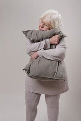 older woman hugging a pillow