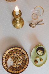 drinking chocolate in matching green cup and plate with assorted baklava desserts on white polka dot tablecloth