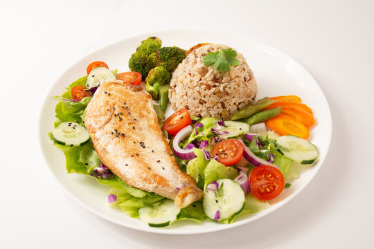 Grilled chicken in a plate with salad and rice isolated clean white background top view photo