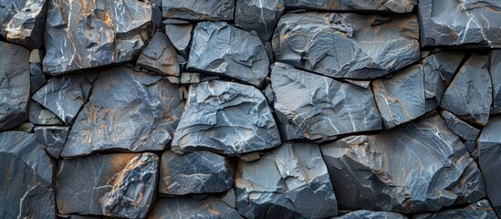 Detailed view of a rock wall composed of dark, weathered rocks.
