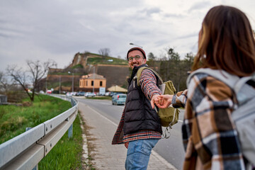 Obraz premium Adventurous travelers sharing a playful walk on the road