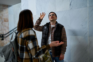 Pair having a disagreement in a hallway leading to a train station.