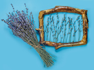 Wooden frames with  bouquet of fragrant lavender in  rustic style on blue wall. Holiday party decoration.