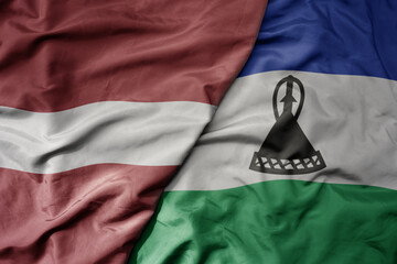 big waving national colorful flag of lesotho and national flag of latvia.