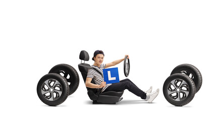 Teenage male driver in a car seat holding L-plate