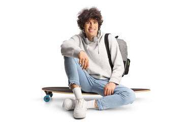 Happy young man sitting on a skateboard - obrazy, fototapety, plakaty