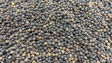 Whole black peppercorns on a spice bazaar stall on the street of Aswan Egypt