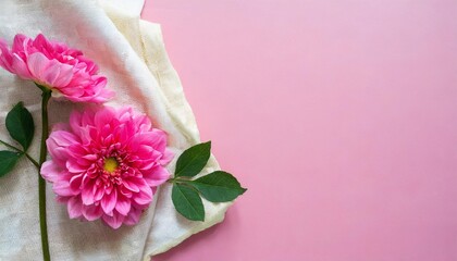 a pink flower with a piece of cloth on a pink surface background a top view picture with copy space on the right to display products or write text - obrazy, fototapety, plakaty