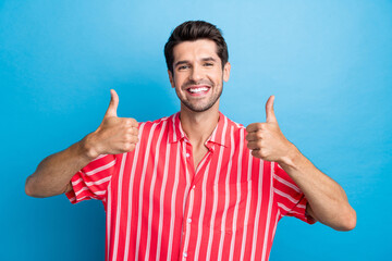 Photo of cool confident man dressed striped shirt showing two thumbs up isolated blue color...