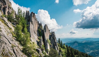 sharp rocks against the sky with clouds on a mountainside with trees - obrazy, fototapety, plakaty