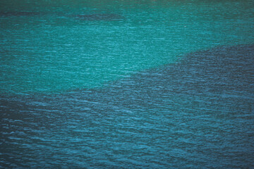 Calm blue turquoise ocean surface. Background texture. Close up mediterranean sea wave. Small waves in sea water reflecting light in the Mediterranean Sea. 