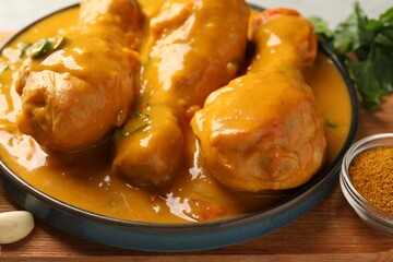 Tasty chicken curry and ingredients on wooden board, closeup