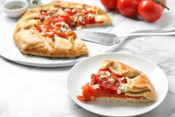 Tasty galette with tomato and cheese (Caprese galette) on white marble table, closeup