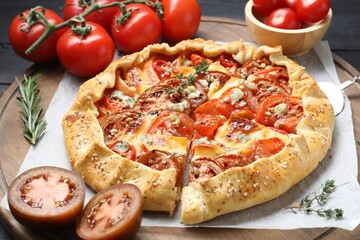 Tasty galette with tomato and cheese (Caprese galette) on wooden board, closeup