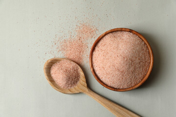Himalayan salt in bowl and spoon on grey background, flat lay