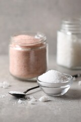 Different natural salt on grey table, closeup