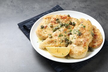 Delicious chicken piccata with herbs on grey table. Space for text