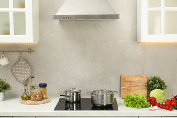 Cooking dinner. Pot, saucepan and fresh vegetables on countertop in kitchen