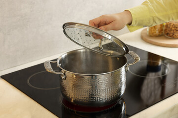 Woman cooking dinner on cooktop in kitchen, closeup