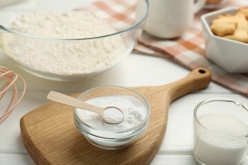 Fototapeta na wymiar Baking powder and sugar on white wooden table, closeup