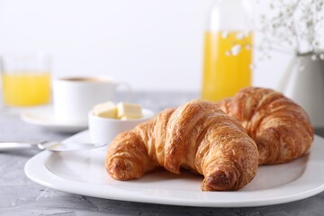 Tasty breakfast. Fresh croissants and butter on grey table, closeup