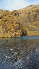 Spectacular river flow near brown edges, natural landscape in nordic region with water pouring down from frozen mountain top. Majestic nature in icelandic wilderness, nordic scenery.