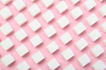 White sugar cubes on pink background, top view
